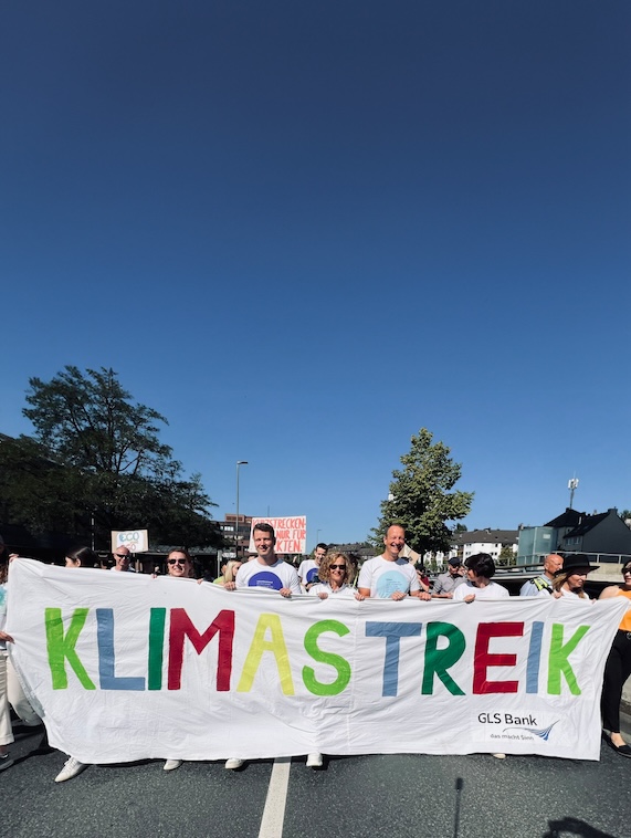 Gruppe von Personen mit einem Schild „Klimastreik“ in den Händen