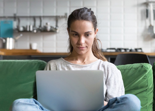 Frau auf Sofa: bequem digital anlegen mit GLS onlineInvest