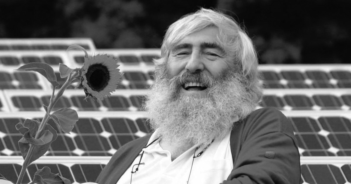 Aus aktuellem Anlass fordern wir: "Rebellische Energie für alle!" Michael Sladek in einem Solarpark mit Sonnenblume.