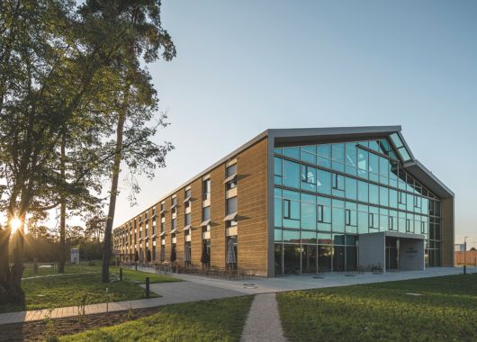 Der Alnatura-Campus in Darmstadt, eine Ansicht von Front und Seite des Gebäudes am Abend beim letzten Licht der Sonne. Foto: Lars Gruber