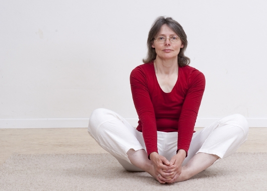 Weiblich gelesene Person im Yogasitz