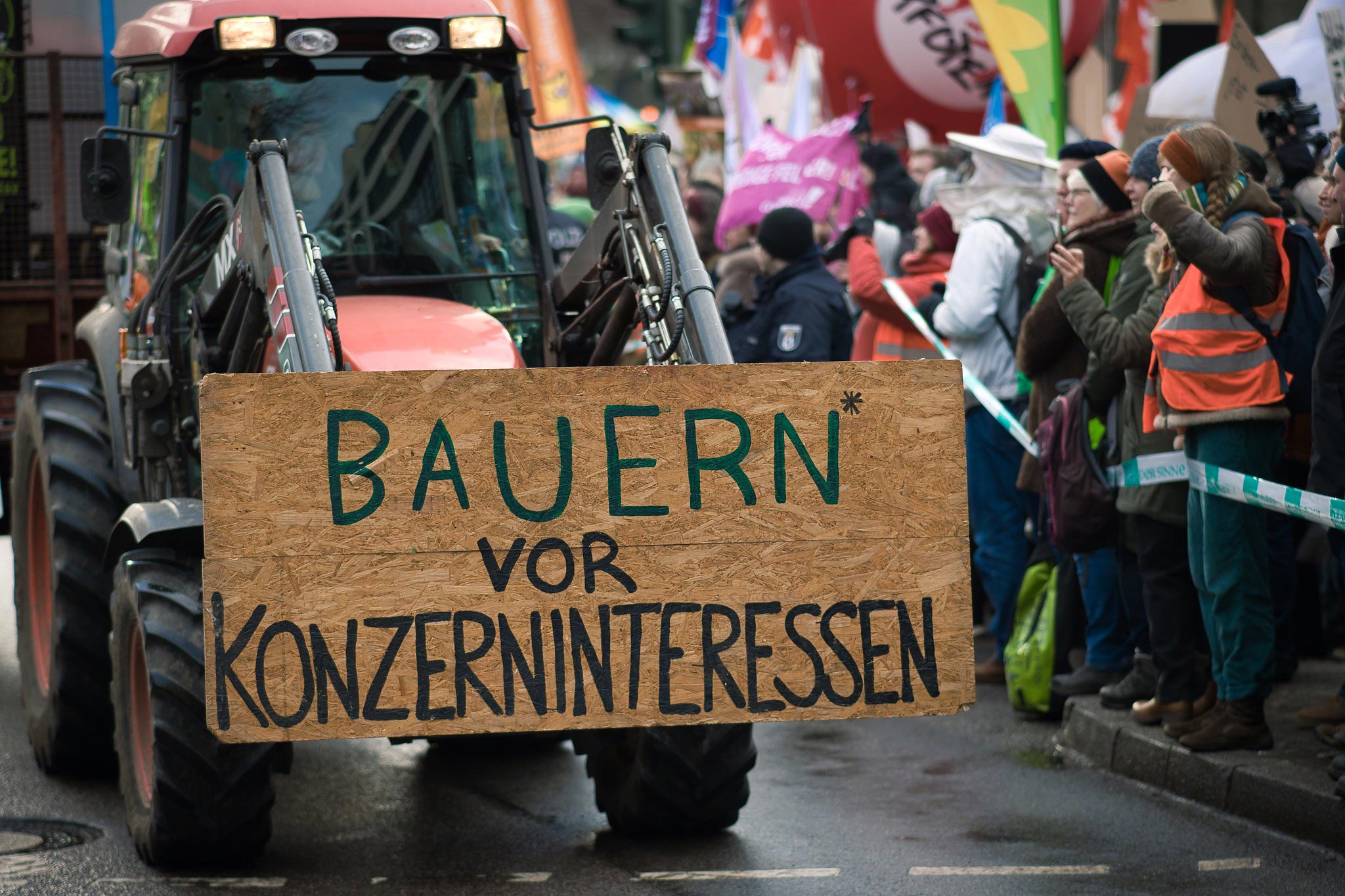 GLS Bank Magazin: Wir haben es satt Traktor mit Schild: Bauern* vor Konzerninteressen