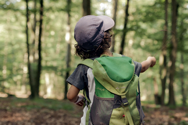 Kind im Wald mit Rucksack