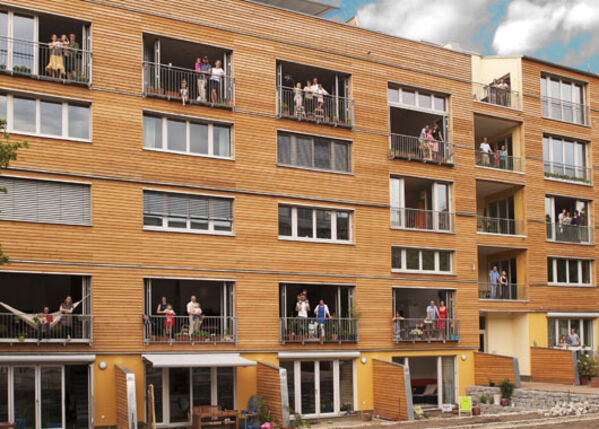 Modernes Haus mit großen Fenstern und Personen.