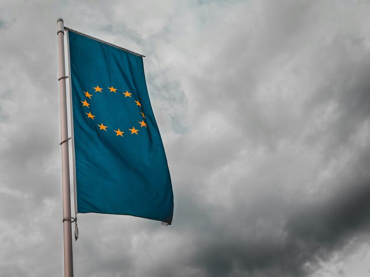 EU Flagge an einem Mast vor einem Himmel mit dunklen Wolken