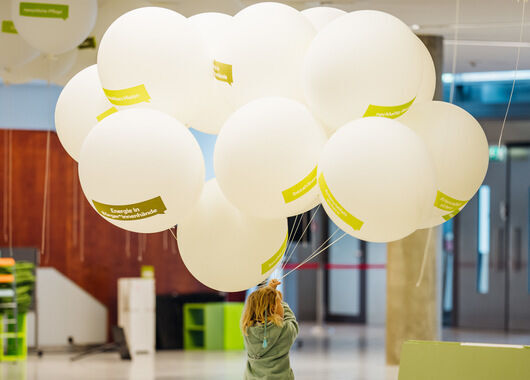 Kind mit Luftballone: GLS Jahresversammlung