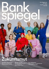 Zwölf Menschen in bunten Overalls posieren an einem bewölkten Tag selbstbewusst im Freien.