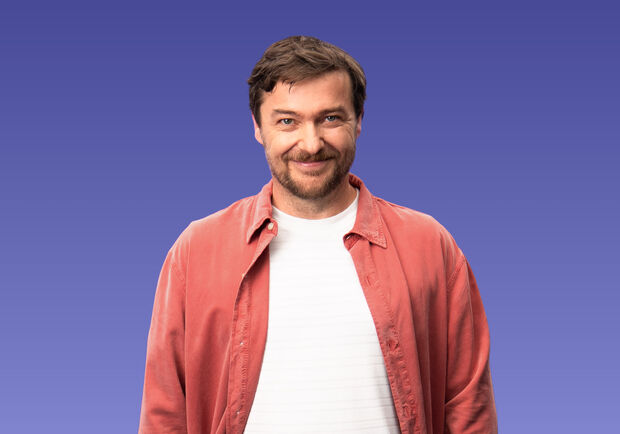 Sebastian Sladek mit offenem rotem Hemd und weißem T-shirt vor lila Hintergrund