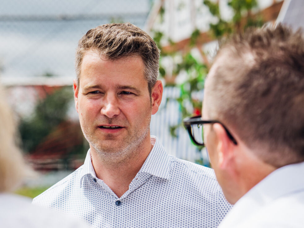 GLS Vorstand Michael Ahlers im Gespräch mit 2 Menschen