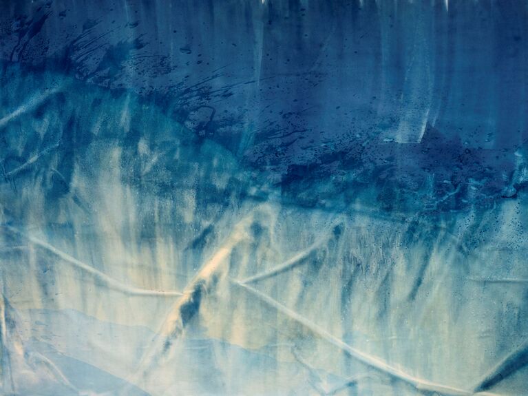 Blaue und beigefarbene abstrakte Textur mit Schlieren und unregelmäßigen Linien, die an Wasserflecken erinnern.