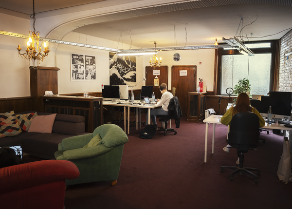 Zwei junge Personen arbeiten im gemütlich aussehenden Arbeitszimmer von Correctiv.