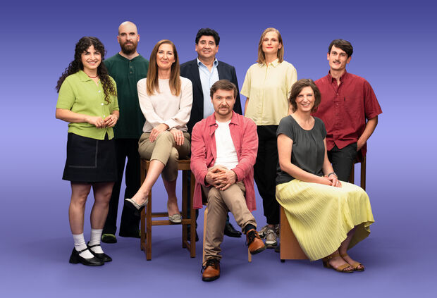 Gruppenfoto von 8 GLS Kund*innen vor einem lila Hintergrund