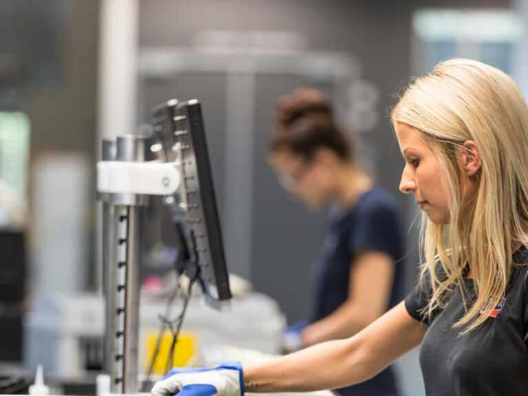 Weiblich gelesene Person an einer Maschine