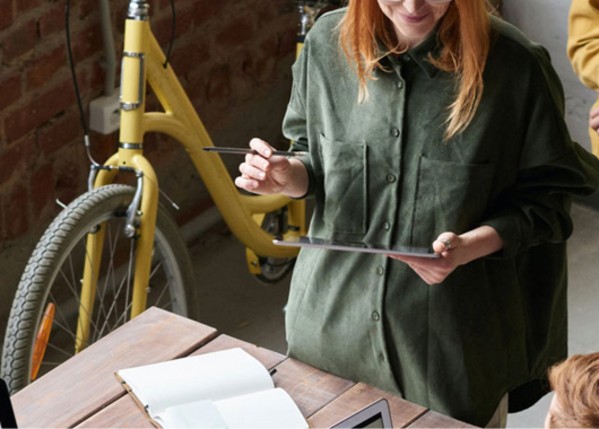 Weiblich gelesene Person am Tablet.