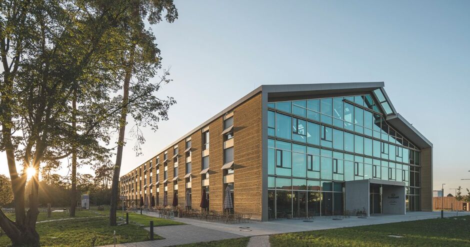 Der Alnatura-Campus in Darmstadt, eine Ansicht von Front und Seite des Gebäudes am Abend beim letzten Licht der Sonne. Foto: Lars Gruber