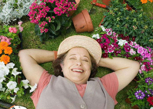 Lächelnde Frau umgeben von Blumen