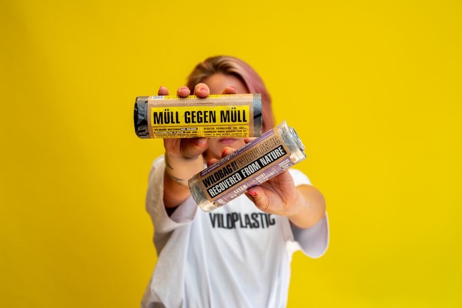 Frau hält nachhaltige Müllbeutel in Kamera