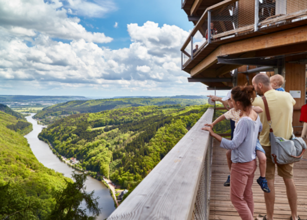 Familie schaut auf eine grüne Umgebung mit Fluss.