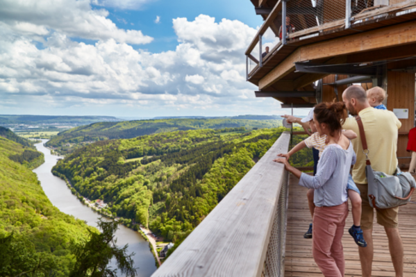 Familie schaut auf eine grüne Umgebung mit Fluss.