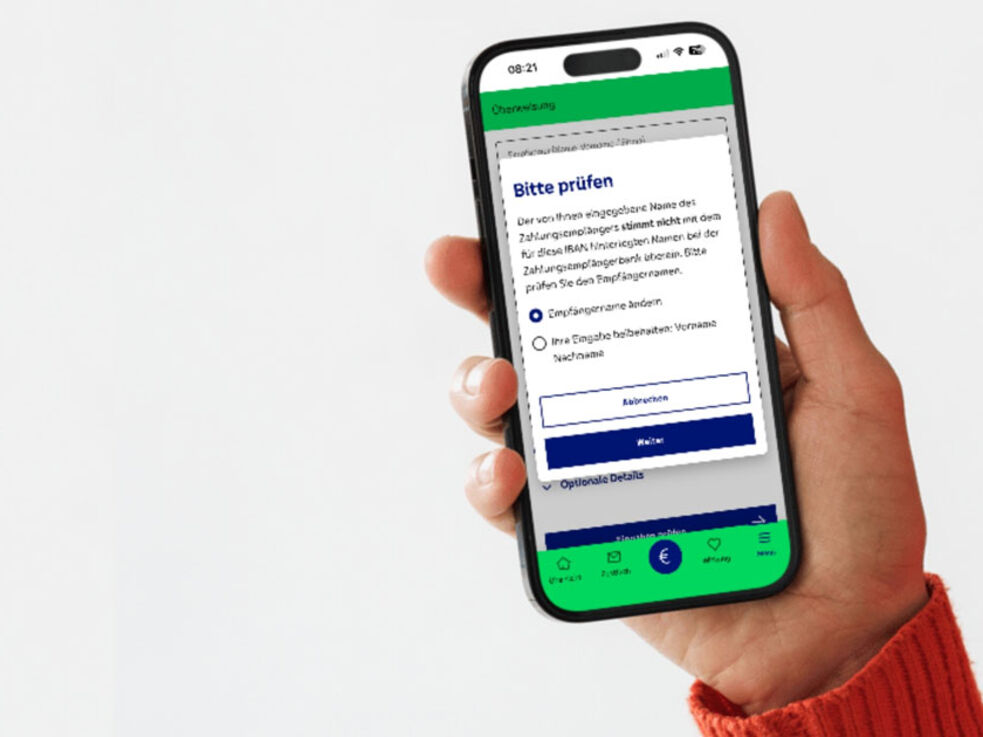 Eine Hand hält ein Smartphone, auf dem ein deutschsprachiger App-Bildschirm mit Kontrollkästchen angezeigt wird.
