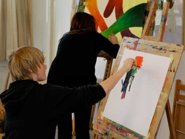 Zwei Künstler*innen malen an Staffeleien