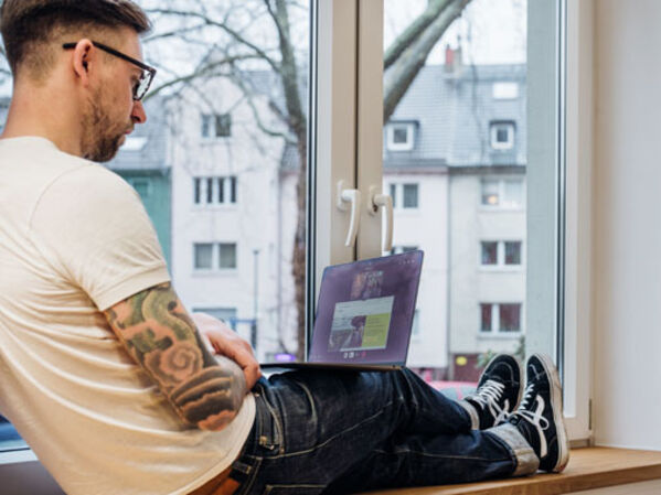 Junge männlich gelesen Person am Latop
