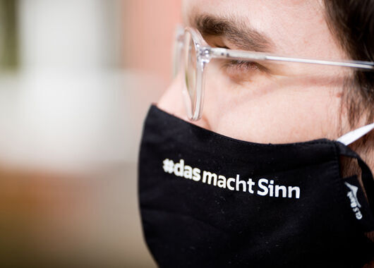 Mitarbeiterin der GLS Bank mit Mund-Nasenmaske bedruckt mit #dasmachtSinn