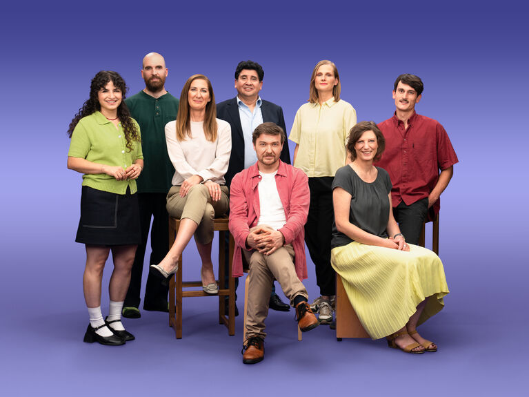 Gruppenfoto von 8 GLS Kund*innen vor einem lila Hintergrund