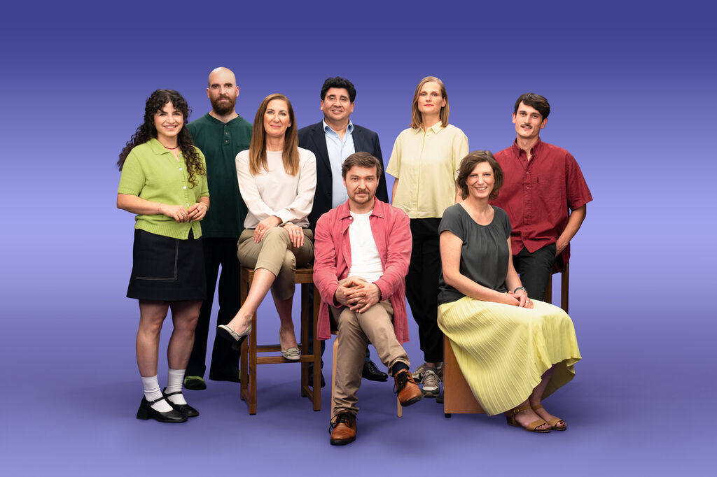 Gruppenfoto von 8 GLS Kund*innen vor einem lila Hintergrund