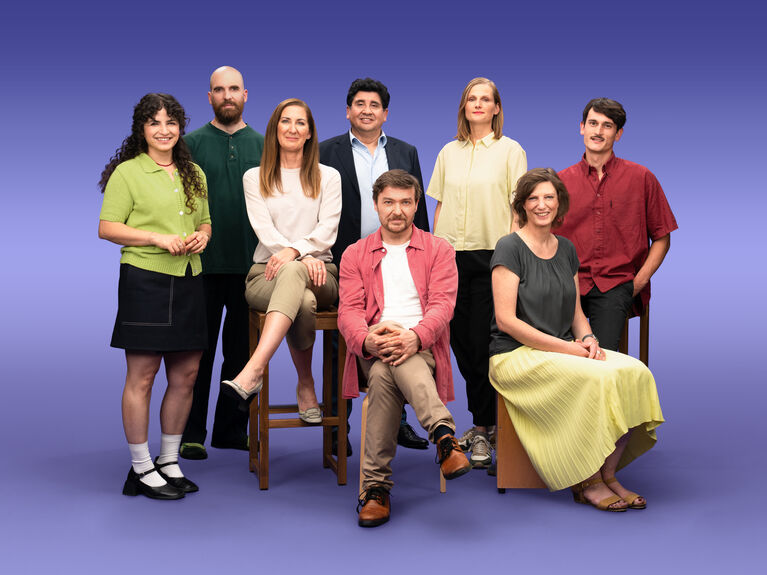 Gruppenfoto von 8 GLS Kund*innen vor einem lila Hintergrund