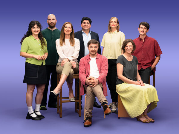 Gruppenfoto von 8 GLS Kund*innen vor einem lila Hintergrund