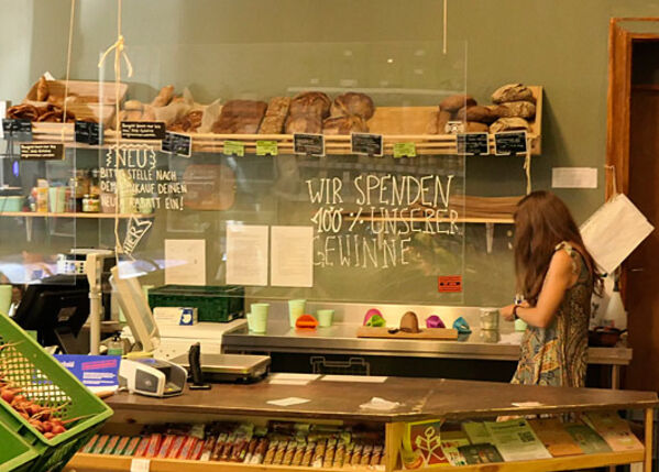 Bioladentheke mit einer weiblich gelesenen Person und Backwaren im Hintergrund.