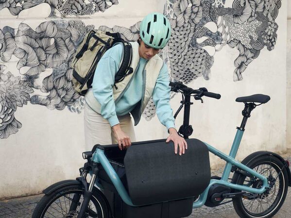 Weiblich gelesene Person mit Lastenrad
