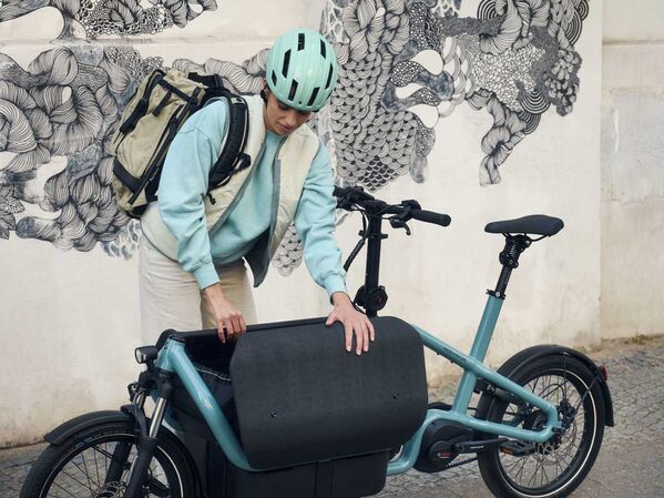 Weiblich gelesene Person mit Lastenrad