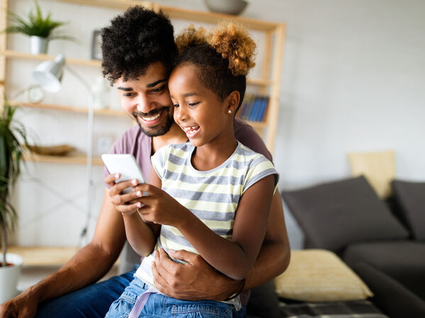 Ein Erwachsener und ein Kind gemeinsam am Handy.