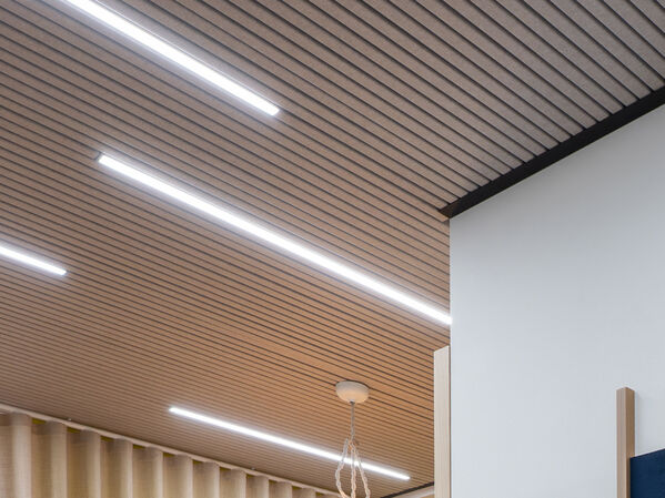 Die Decke eines Büros aus Holz Panelen mit Lichtern.