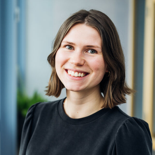 Eine junge weiblich gelesene Person mit braunen schulterlangen Haaren.