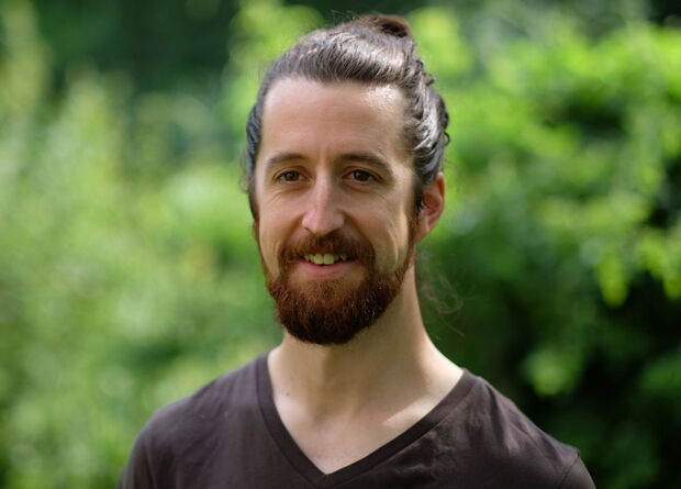 Männlich gelesene Person mit braunen Haaren und T-Shirt