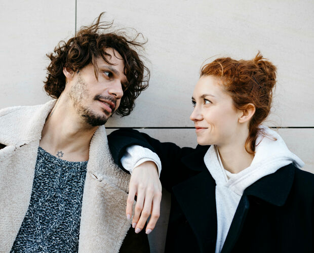 Junger Mann und junge Frau lächeln sich an