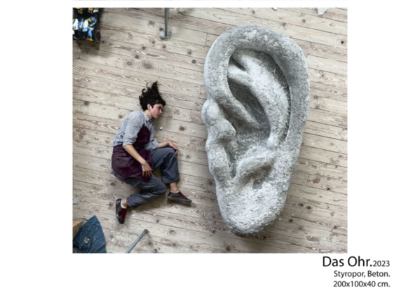 Bild von großem Ohr aus Styropor daneben Mensch Bild von großem Ohr aus Styropor daneben Mensch