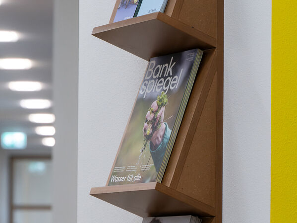 Halterung aus Holz für Magazine an einer Wand.