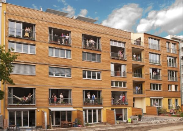 Modernes Gebäude mit Holzfassade und großen Fenstern.